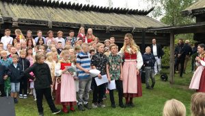 En grupp skolelever. Fem barn längst fram med diplom i händerna.